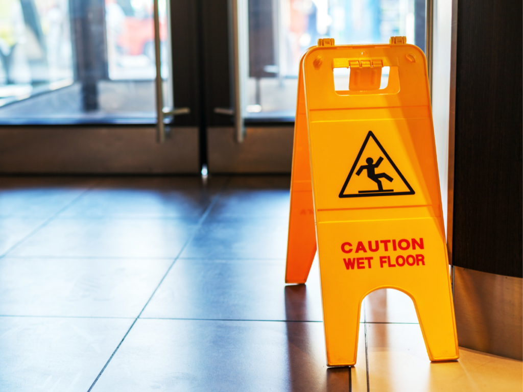 A yellow wet floor sign in a shopping mall.