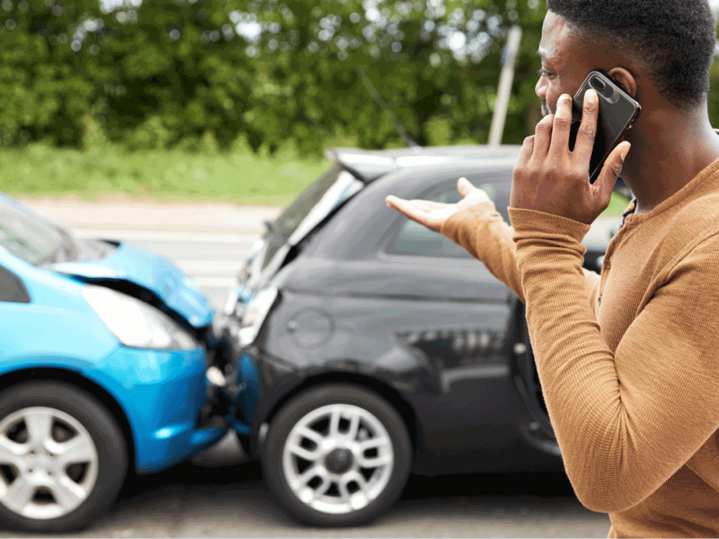 A car accident in the background and someone on the phone