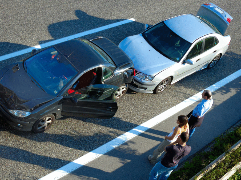 Two cars are stopped on the side of a highway after a rear-end collision, with visible damage to both vehicles’ front and rear bumpers. The drivers and passengers stand nearby discussing the crash. The image illustrates how low-speed rear-end accidents can still cause serious injuries such as whiplash, herniated discs, and concussions, emphasizing the importance of proper medical documentation and legal claims in Wyoming.