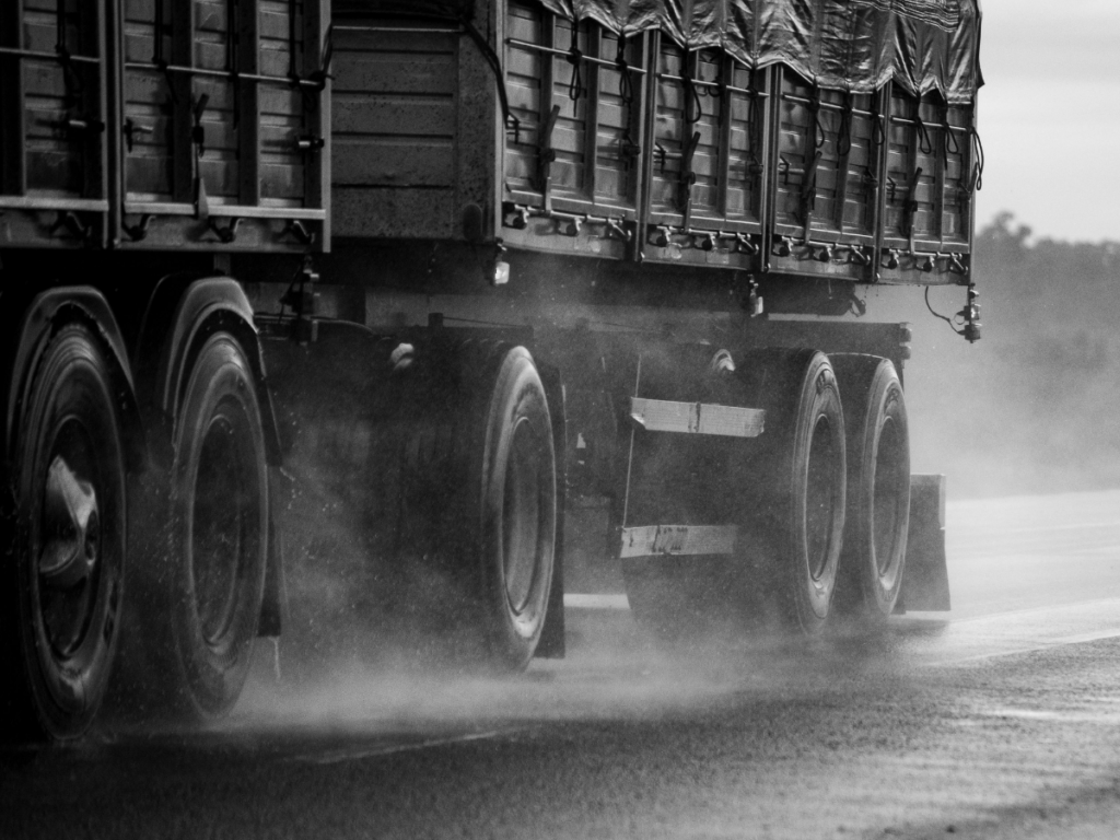 Large mining haul truck driving on a wet roadway, illustrating the risks and potential liability issues involved in Wyoming mining truck accident cases.
