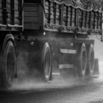 Large mining haul truck driving on a wet roadway, illustrating the risks and potential liability issues involved in Wyoming mining truck accident cases.