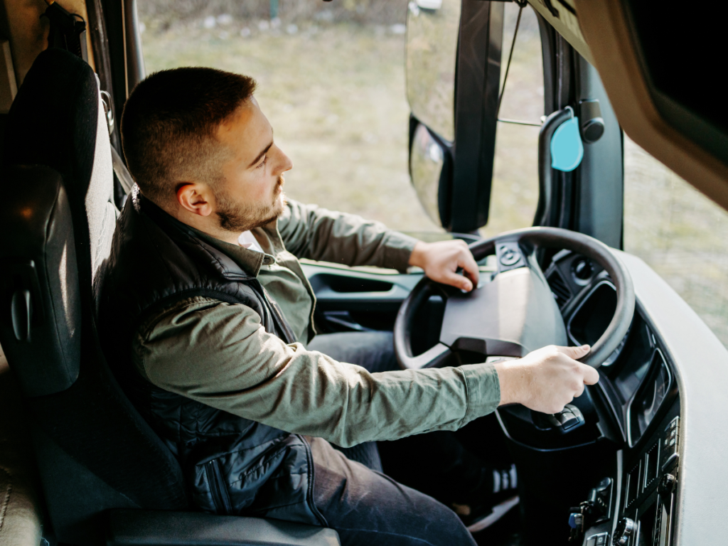 A commercial truck driver sits behind the wheel, focused on the road ahead, illustrating how driver qualifications and employer oversight play a critical role in preventing truck accidents and ensuring roadway safety.