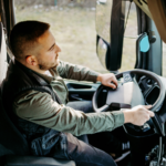 A commercial truck driver sits behind the wheel, focused on the road ahead, illustrating how driver qualifications and employer oversight play a critical role in preventing truck accidents and ensuring roadway safety.