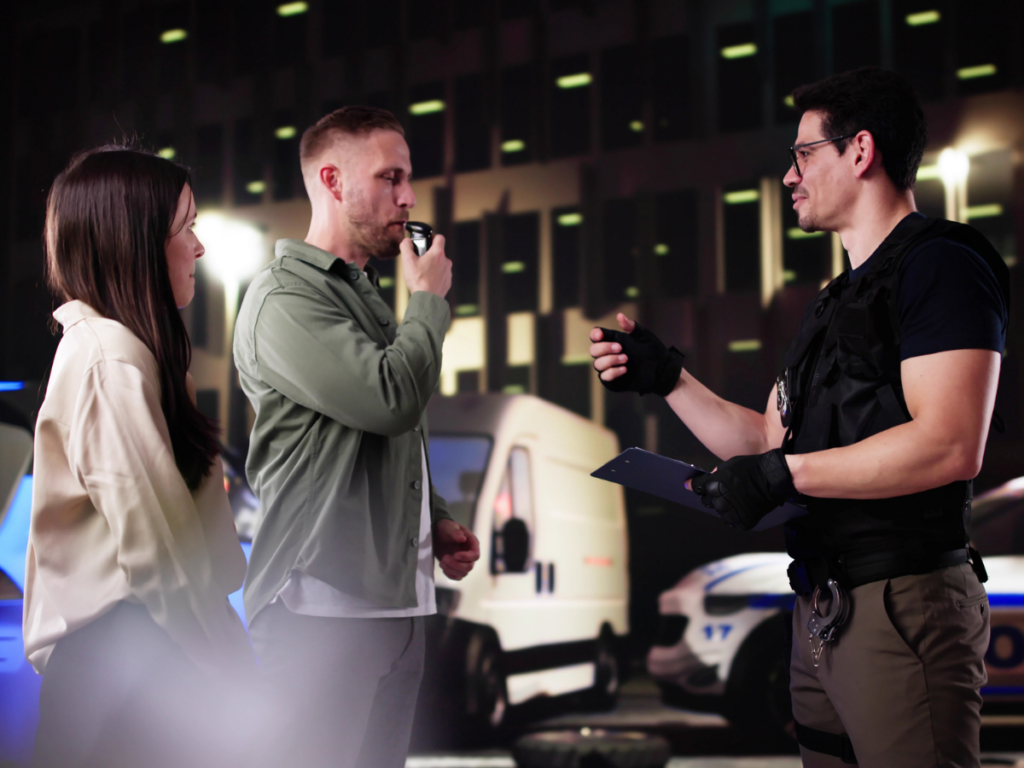 A nighttime DUI stop where a police officer administers a breathalyzer test to a driver during a traffic stop, illustrating how blood alcohol concentration (BAC) is measured and used as evidence in high BAC DUI cases in Sundance, Wyoming.