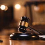 Close-up of a judge’s gavel resting on a sound block inside a courtroom, symbolizing criminal court proceedings, plea negotiations, and legal decision-making.